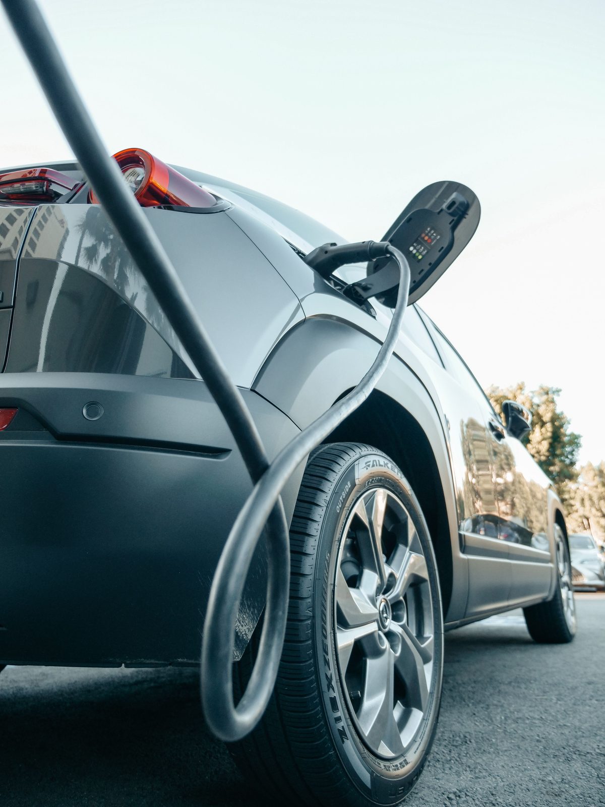 An electric vehicle connected to a charge point, cable and connector in use